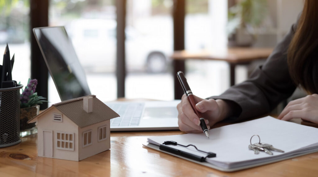 How to Sell my House Warner Robins: real estate realtor working in the office, reviewing rental contract on papers. Property consultant working in a modern office.